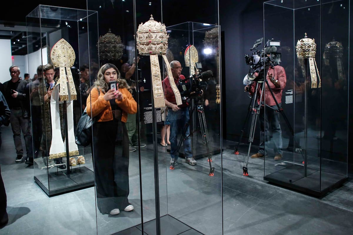 Members of the media look at Papal Tiaras from the Sistine Chapel during the press preview for the annual fashion exhibit "Heavenly Bodies: Fashion and the Catholic Imagination" at The Metropolitan Museum of art on May 7, 2018 in New York. / AFP PHOTO / KENA BETANCUR