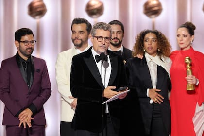 Mendonça Filho agradece el Globo de Oro que obtuvo como mejor film internacional; detrás, actores y productores de El agente secreto