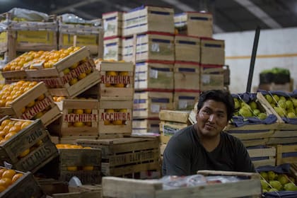 En medio del paisaje de cajones de madera y frutas y verduras de todos los colores, cientos de bolivianos trabajan sin cansancio.