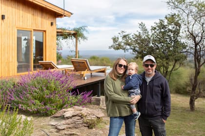 Mercedes Lascano, Guillermo Neumann y su hijo Teo entre las cuatro cabañas estilo nórdico de diseño sustentable