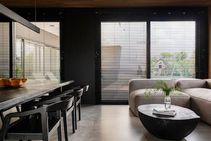 Mesa baja de madera quemada y sillón modular tapizado en un género símil cuero muy fácil de limpiar, todo a medida por Malé.