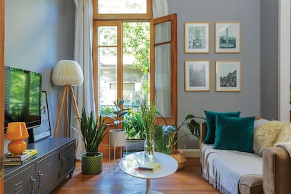 Mesa blanca con tapa y base redondas (Buenos Aires Design). En la pared, cuadros con imágenes de Buenos Aires, regalo de un amigo. El piso original de pino tea fue limpiado e hidrolaqueado.