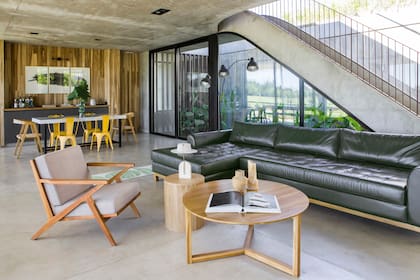 Mesa compacta circular enchapada en madera (Regio). Floreros hechos a partir de hongos (Pilar Urruti Studio). Alfombra rectangular (Caucus Lab).