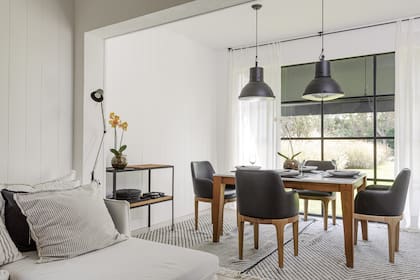 Mesa con tapa de mármol y sillas de cuero negro, todo en madera de petiribi. Lámparas colgantes (Ikea) traídas de un viaje. Paredes revestidas en 'Cedral' (Durlock)
