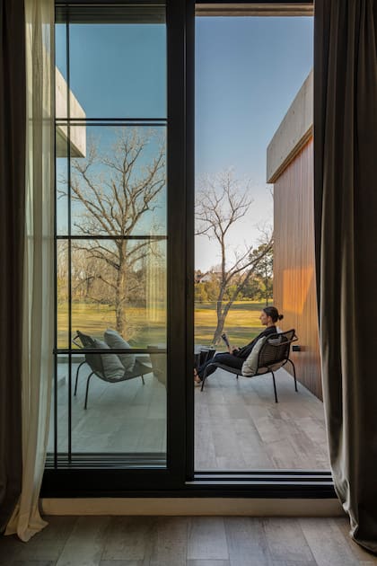 Mesa de centro de raíz quemada y sillones 'Agnoli' con almohadones.