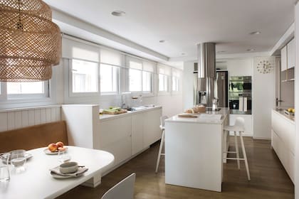 Mesa de comedor, bajomesadas y alacenas en MDF con pintura poliuretánica gofratto, un tipo de laqueado más resistente que el tradicional. Lámpara colgante ‘Sinnerlig’ de Ilse Crawford (Ikea). Reloj de pared (Vitra).
