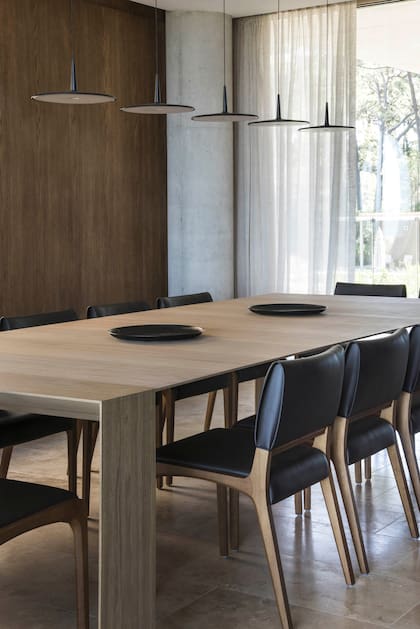 Mesa de comedor ‘Elle’ con sillas ‘Anna’ de madera y cuero (Sollos). Conjunto de lámparas suspendidas ‘Skan’, diseño del estudio Lievore Altherr Molina (Vibia).