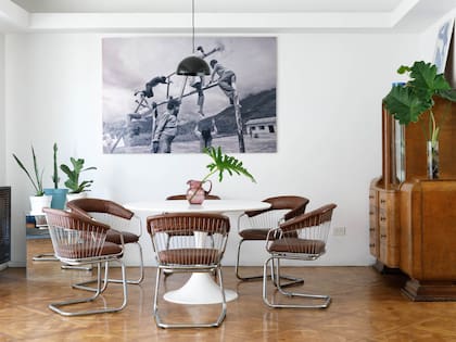 Mesa de comedor estilo ‘Tulip’ (Mercado Libre). Sillas estilo ‘Bertoia’ retapizadas en cuerina color suela (Mercado de Pulgas). Fotografía en blanco y negro de Martín Linietsky. Plantas de interior (Planta).