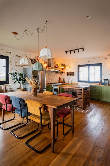 Mesa de comedor reciclada con sillas tapizadas con los colores primarios. Pero el protagonismo se lo lleva el verde, uno de los grandes elegidos en este tipo de cocinas.