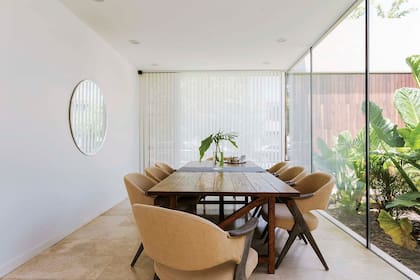 Entre el living y la cocina, se encuentra el comedor que mira hacia los espacios verdes de la casa.