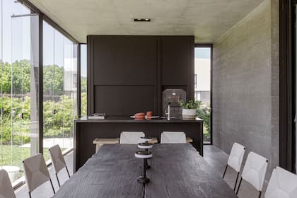 Mesa de madera quemada (Primitiva) y sillas (Las Marinas). Isla con mesada de granito ‘Negro Absoluto’.