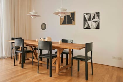 Mesa de teka (Sika Design) y sillas de cuero. Lámparas colgantes ‘PH 5’ (Louis Poulsen). Obras (Monocopia).