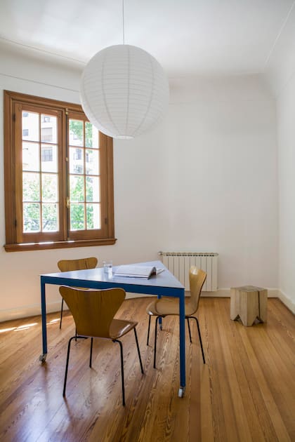 Mesa diseñada por el arquitecto Facundo Fernández (Flora Oficina). Sillas vintage ‘Serie 7’, de Arne Jacobsen; su terminación reitera casi con exactitud el tono del piso y de las aberturas. Taco ‘Álamo’ (La Base Studio).