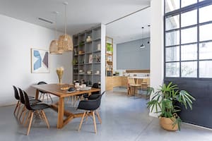 Mesa ‘enna’ de madera maciza con tapa enchapada en petiribí (Cia Wood Ideas), sillas Eames ‘DSW’ (Del Sur Design), pantallas de bambú ‘Lola’ (Compañía Nativa) y acrílico enmarcado (Färg Art).