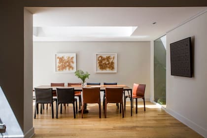 Mesa extensible en ébano del sublime diseñador danés Helge Vestergaard-Jensen; sillas ‘CAB’, de Mario Bellini (Cassina), dos obras de Leticia Gelosi y otra de Luis Tomasello.