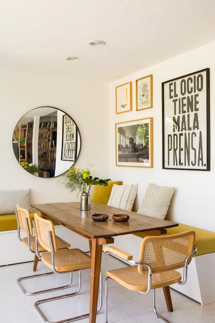 Mesa (La Base Estudio) con sillas ‘Cesca’ (Michael Thonet). Bancos de obra con colchonetas (Sillones Europea). Foto tomada por Cecilia Espinosa, afiche de Mala Prensa y cuadro bordado de Caro Malbrán.