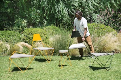 Mesa y sillas de hierro y cemento, en una combinación moderna y de líneas finas para integrar al jardín.