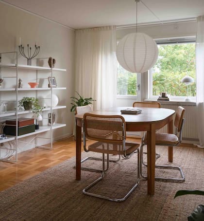 Mesa y sillas voladizas estilo 'Cesca', todo comprado de segunda mano. Estantería 'Enetri', lámpara y alfombra de yute (todo de Ikea).