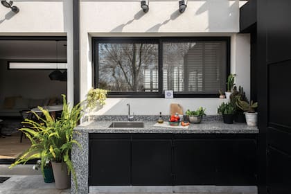 Mesada de granito ‘Gris Perla’ fiamantado (Oscar Revestimientos), puertas del bajomesada y cerramiento para parrilla en hierro (MTD Arquitectura).