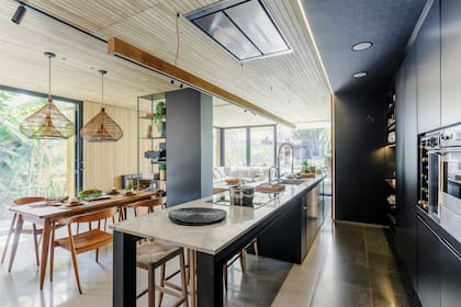 Mesada de isla y bacha en granito ‘Silverwhite’ (Marmolería Cavatori). Muebles de cocina en MDF laqueado negro (Racadafe). Grifería Hansgrohe ‘K7’ (Arredobagno).