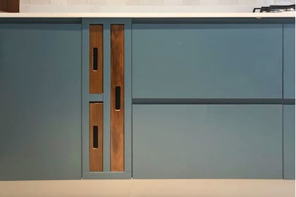 Mesada de Silestone "Calacatta Gold", bandejas de madera a contratono y cajones con guías escondidas de cierre suave.