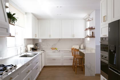 Mesada en Dekton ‘Natura’ y barra en Dekton ‘Aura’ (Marmolería Ragolia). Banquetas (Caro Prieto Interiors). Apliques de pared (Margarita Forteza). Piso de porcelanato símil madera (SBG).