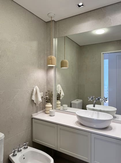 Mesada, Silestone Blanco Norte (Canteras del Mundo por Marmolería Cervaiole). Mueble (diseñado y ejecutado por el estudio, en el tono Agreeable Gray de Sherwin Williams). Revestimientos piso y pared (Cifre XS Norwich White – Syria), revestimiento de pared protagonista (Portobello Aeterna Bianco – SBG). Bacha: Lea Oval Roca