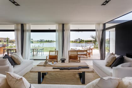 Mesas de centro de kiri con base de hierro, aofás tapizados en tussor con funda blanca; sillones y mesa de arrime (todo de Carola Mauer).