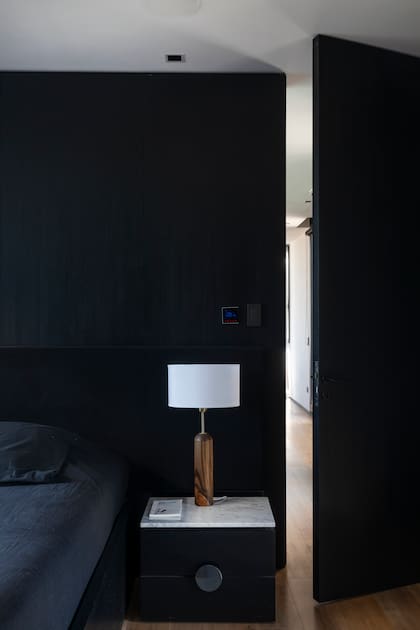Mesas de luz en madera negra con tapa de mármol de Carrara.