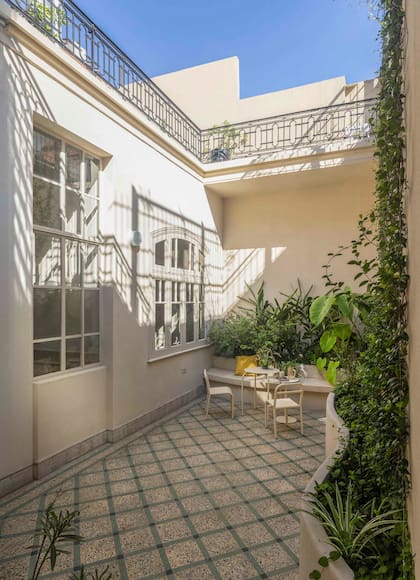 Mesas y sillas de hierro (Intervista). Arriba, la terraza, que balconea hacia este pulmón.