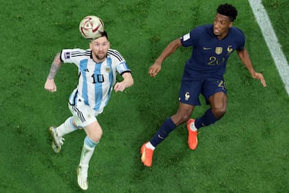 Messi busca la próxima jugada magistral, marcado por el delantero francés Kingsley Coman durante la final de la Copa del Mundo