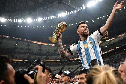 Messi, con la Copa del Mundial (Photo by Anne-Christine POUJOULAT / AFP