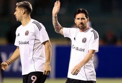 Messi, con su pelo largo, saluda al público acompañado de Luis Suárez
