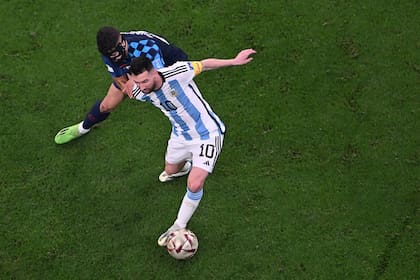 Messi cubre la pelota ante Gvardiol mientras girar para asistir a Álvarez