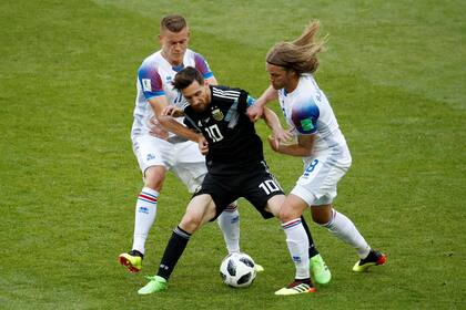 Messi pelea la pelota con los jugadores Birkir Bjarnason y Alfred Finnbogason