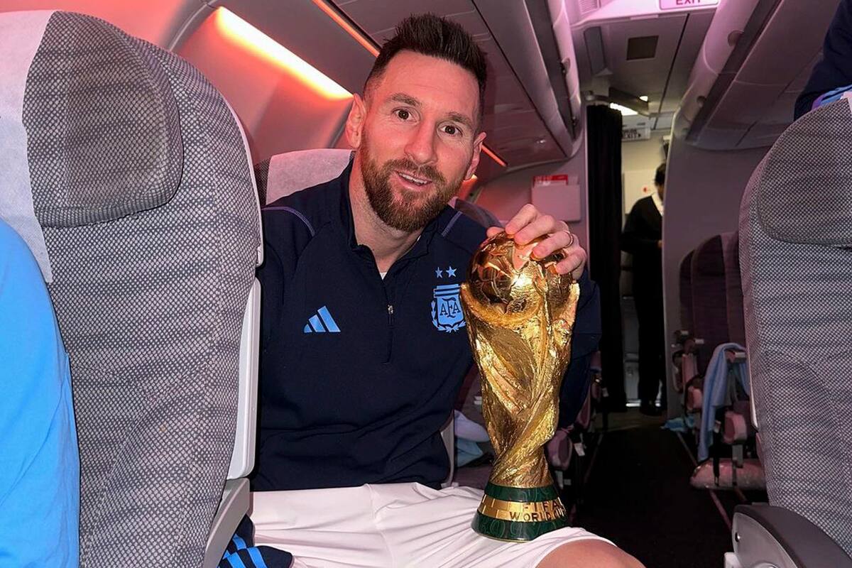Messi en el avión de regreso a Argentina, con el trofeo