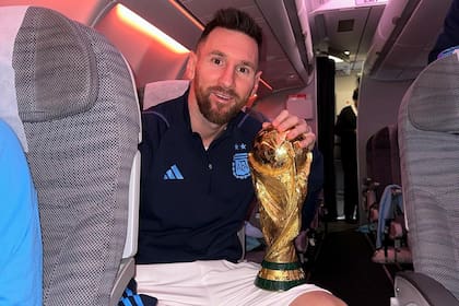 Messi en el avión de regreso a Argentina, con el trofeo