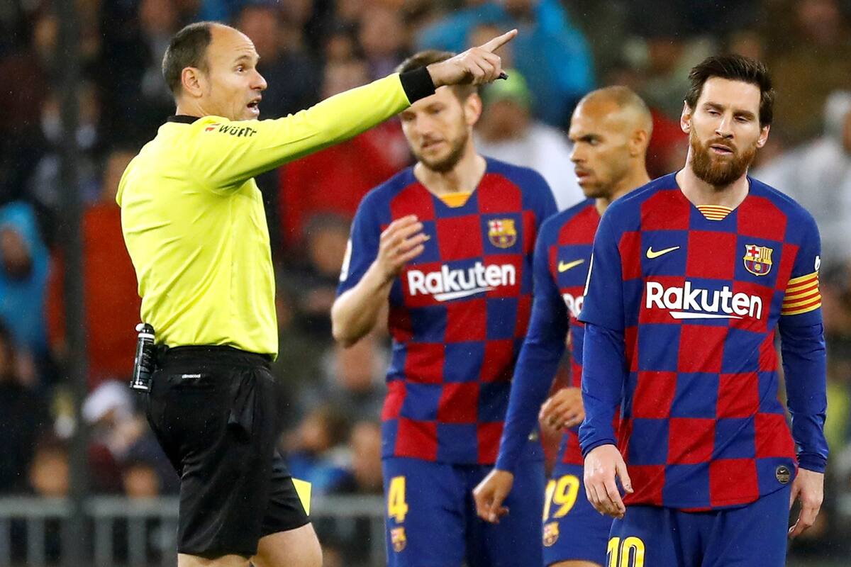 Messi, impotente, observa a Mateu Lahoz, el árbitro del clásico