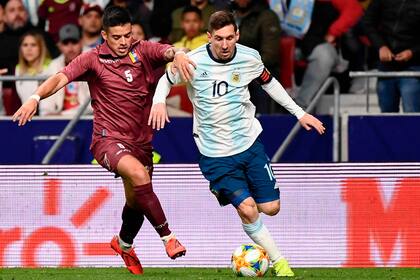 Messi intenta gambetear a Junior Moreno; el 10 no tuvo un partido destacado