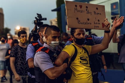 "Messi, quedate en casa. Barcelona te ama", ruega el cartel casero de este simpatizante al que se llevan los "mossos d´Esquadra".