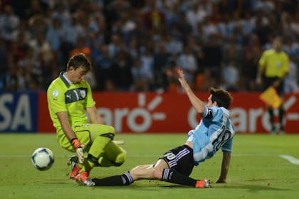 Lionel Messi se estira y vence al arquero Fernando Muslera en el 3-0 de la Argentina sobre Uruguay en Mendoza en 2012, por la eliminatoria rumbo al Mundial Brasil 2014.