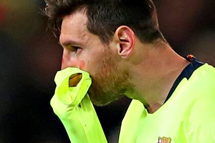Messi se toma la nariz luego de recibir el golpe