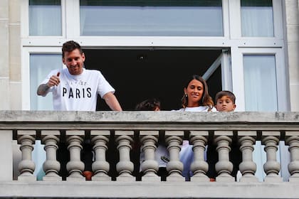 Messi, su esposa Antonella y uno de sus hijos saludan ayer a los fanáticos del PSG que se acercaron a celebrar su llegada