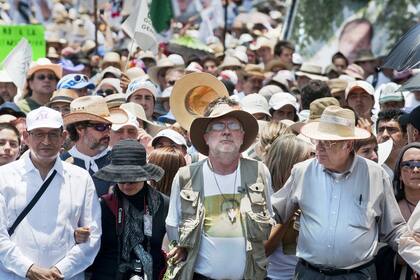 Mexican poet and journalist Javier Sicilia (C) --whose son Juan Francisco Sicilia (24) was murdered on March 27-- and other activists, walk during the last of a four-day silent march to protest drug violence --which has left tens of thousands dead-- and the military strategy that has failed to stop it, in Mexico City, on May 8, 2011. The marchers set off last May 5 from the city of Cuernavaca, a popular weekend retreat some 55 miles (90 km) south from the capital, and it is due to end with a massive demonstration in the Zocalo, the main square of Mexico City. AFP PHOTO/Ronaldo Schemidt