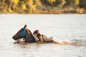 Mía Röhner es hija de Augustito y lidera los cruces a caballo por el río.