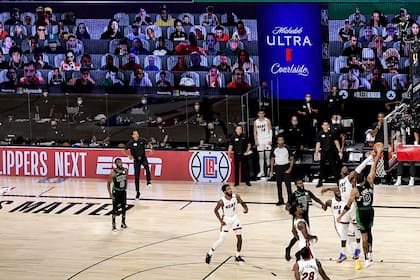 A la vanguardia de la innovación, la NBA fue una de las primeras organizaciones en idear una burbuja y en poblar de público virtual sus estadios, como en este encuentro entre Miami Heat y Boston Celtics en los playoffs.