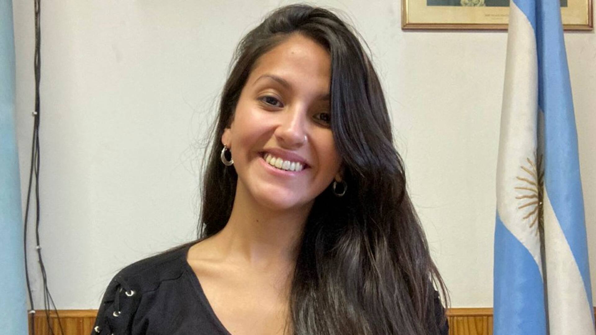 Micaela Bilbao, intendenta de Lago Blanco, en su despacho, junto a la bandera argentina