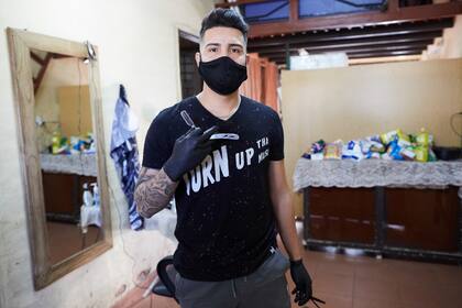 Michael Kevin Guerrero, de 22 años, un joven entrenador de fútbol infantil mendocino, a punto de recibirse de profesor de Educación Física, brinda sus servicios como barbero, de manera gratuita. Ofrece cortes por mercadería para un comedor infantil.