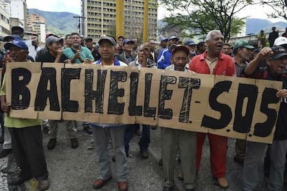 Manifestantes venezolanos saludan la llegada de Bachelet durante una visita al país de la funcionaria de la ONU, en 2019