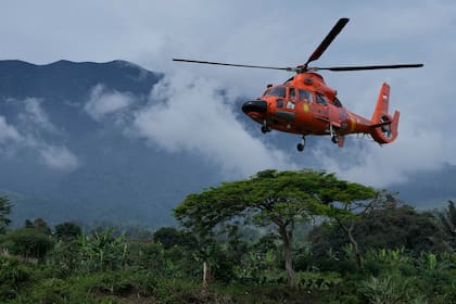 Miembros de la Agencia Nacional de Búsqueda y Rescate se trasladan en un helicópetro el sábado 26 de noviembre de 2022 para llevar materiales de asistencia a un poblado afectado por el sismo el 21 de ese mes en Cianjur, Java Occidental, Indonesia, el sábado 26 de noviembre de 2022. (AP Foto/Achmad Ibrahim)